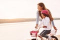 Learning how to drive. Mother with her young daughter is with bicycle outdoors together Royalty Free Stock Photo