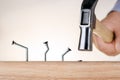 Learning from mistakes Businessman  hammering nails. Royalty Free Stock Photo