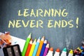 Learning never ends text on blackboard with office tools Royalty Free Stock Photo