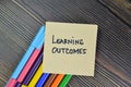 Learning Outcome write on sticky notes isolated on Wooden Table Royalty Free Stock Photo