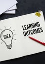 Learning outcomes and idea visualization with lightbulb illustration on opened notebook Royalty Free Stock Photo
