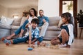 Learning through play. two young siblings playing with their toys while their parents sit and watch in the background. Royalty Free Stock Photo