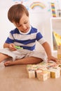 Learning through play. a young boy playing with his building blocks in his room. Royalty Free Stock Photo