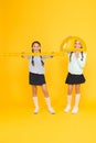 Learning school geometry. School children with measuring instruments on yellow background. Cute pupils holding