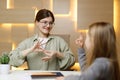 Learning sign language, cheerful woman communicates with a child. School for the deaf or dumb Royalty Free Stock Photo