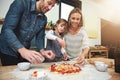 Learning, smile and family baking pizza in kitchen together, bonding and happy in home. Food, mother and father with kid Royalty Free Stock Photo