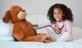 Learning, teddy bear and girl playing with stethoscope, having fun or acting like doctor in bedroom. Portrait, education Royalty Free Stock Photo