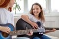 Learning to play the guitar. Female teacher explains to child the basics of playing guitar Royalty Free Stock Photo