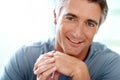 Learning to relax. Headshot portrait of a handsome mature man smiling while looking at the camera during the day. Royalty Free Stock Photo