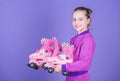 Learning to skate is fun. Cute little skater. Small girl holding pink roller skates. Little child with inline skates