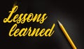 Lessons Learned words written on black with yellow pencil besides. Education or business crisis management concept Royalty Free Stock Photo