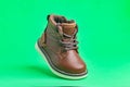 Leather baby boot with laces on a green background. Concept of modern fashion Royalty Free Stock Photo