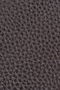 Leather background, brown, bumpy, textured. Bonded reconstituted leather. Substitute for genuine natural material. Dark backdrop