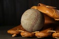 Leather baseball glove with old worn ball on wooden table, closeup Royalty Free Stock Photo