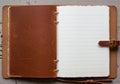 A leather-bound notebook is open on a textured surface. The left Royalty Free Stock Photo