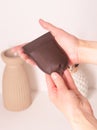leather brown coin case with in woman hands closeup photo on white wall background