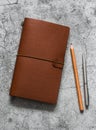 Leather brown personal organizer, pen, pencil  on a gray table, top view. Business concept, copy space Royalty Free Stock Photo