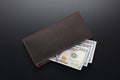 Leather brown wallet with dollars on black table Royalty Free Stock Photo