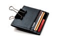 Leather cardholder with credit cards on a white background. Cardholder clamped by a paper clip. The symbol of the electronic