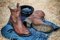 Leather cowboy boots leather belt and jeans on straw Royalty Free Stock Photo