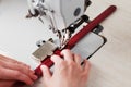 A leather craftsman produces leather goods on a sewing machine in his shop