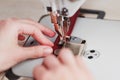 A leather craftsman produces leather goods on a sewing machine in his shop