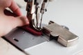 A leather craftsman produces leather goods on a sewing machine in his shop