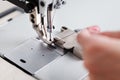 A leather craftsman produces leather goods on a sewing machine in his shop