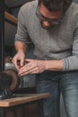 Leather craftsman sharpens knife for cutting leather on sander. Handmade concept. Concept of small business to create leather