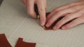 Leather craftsman works in his workshop. Master making leather wallet. Man cuts a leather shape with a bevel cutter. Guy