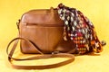 Brown leather handbag and silk scarf. Royalty Free Stock Photo