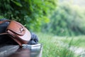 Leather handbag, smartphone and jacket on a park bench, nobody
