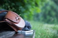 Leather handbag, smartphone and jacket on a park bench, nobody