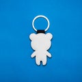 Leather key ring in bear shape on blue paper background. Blank key chain for your design Royalty Free Stock Photo