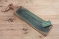 Japanese leather craft knife on a leather knife strop with green polishing compound on a wooden surface Royalty Free Stock Photo