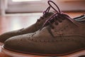 Leather Men`s Brogue Shoes with Colored Laces on The Floor with Back Light Closeup