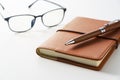 Leather notebook, pen and glasses placed on a white background Royalty Free Stock Photo