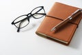 Leather notebook, pen and glasses placed on a white background Royalty Free Stock Photo