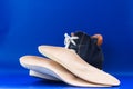 Leather orthopedic insoles with boot. Blue background.