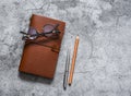 Leather personal organizer, pen, pencil, glasses  on a gray table, top view. Business concept Royalty Free Stock Photo