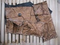 Leather pouch made of fresh zombie skin with green bloody eye and scars stitched with brown thread top view