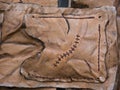 Leather pouch made of fresh zombie skin with scars stitched with brown thread top view