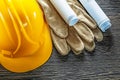 Leather protective gloves construction plans hard hat on wooden Royalty Free Stock Photo