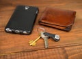 Leather purse, phone pouch and keys on a wooden table background Royalty Free Stock Photo