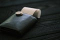 A leather purse and small stack of coins on black wooden table Royalty Free Stock Photo