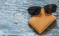 leather purse with sunglasses lying on a wooden table Royalty Free Stock Photo