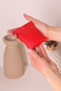 leather red coin case with in woman hands closeup photo on white wall background