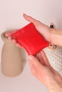 leather red coin case with in woman hands closeup photo on white wall background Royalty Free Stock Photo
