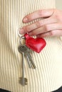 Leather red heart key trinket as a valentines day gift closeup photo on white sweater background Royalty Free Stock Photo