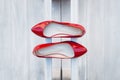 Leather red women& x27;s shoes on a white wooden shelf. Fashion, minimal fashion concept, women& x27;s shoes, accessories. red